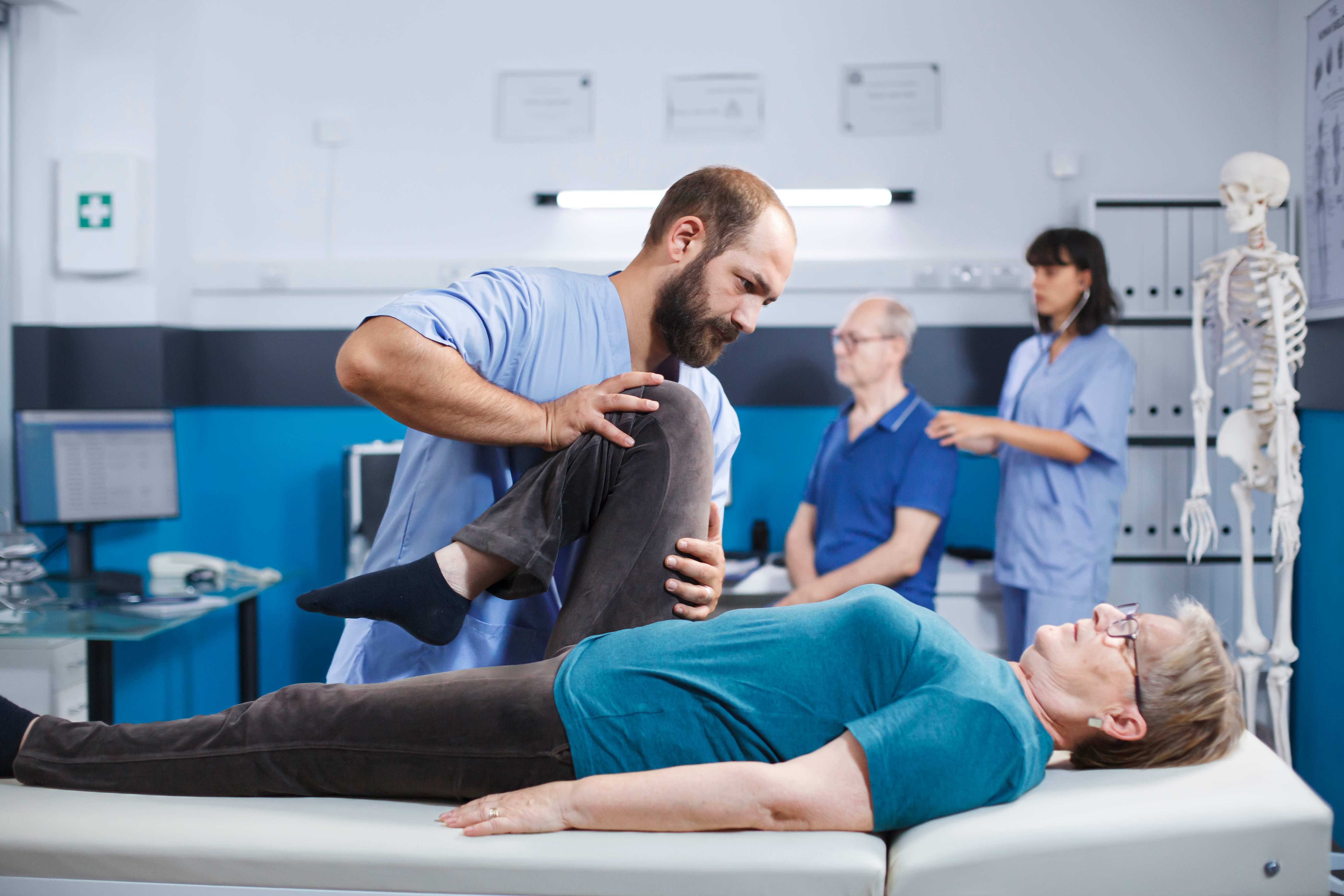 Physical therapist helping patient with leg exercises